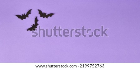 Halloween decorations, pumpkins, on violet background. Halloween party greeting card. Copy space. Flat lay, top view, overhead.