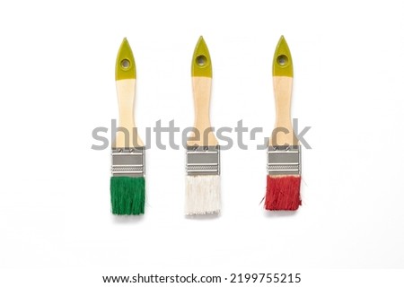 Paint brushes on white background. Flat lay. Paintbrushes in the colors of the national flag of Italy.