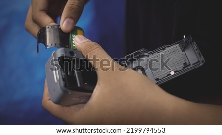 The hand changing the old camera roll Royalty-Free Stock Photo #2199794553