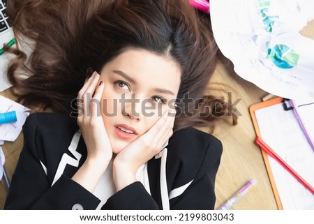 Top view beautiful young asian businesswoman feeling tired from work in the office. Portrait of a casual stressed lady with a headache at desk, an Exhausted businesswoman.