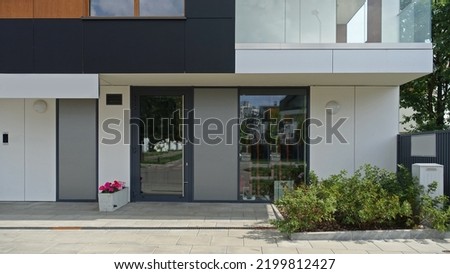 Modern residential building with balconies. Entrance to a store or office. Royalty-Free Stock Photo #2199812427