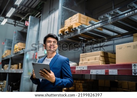 Portrait of a confident Asian businessman investor in Asia standing in a large warehouse and warehouse environment, factory, distribution, business owner and investment idea, industry, warehousing.