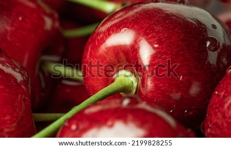 Red juicy sweet cherries. Juicy maroon fruit close-up. Cherries in magnification with light reflections. Sweet fruit. Royalty-Free Stock Photo #2199828255