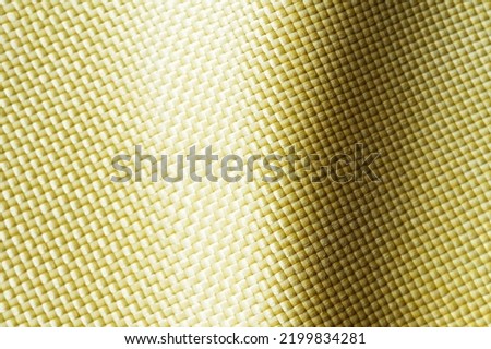 Selective focus. Bulletproof material aramid. Aramid kevlar background. Golden kevlar texture and pattern. 