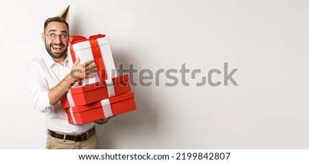 Holidays and celebration. Excited man having birthday party and receiving gifts, looking happy, standing over white background