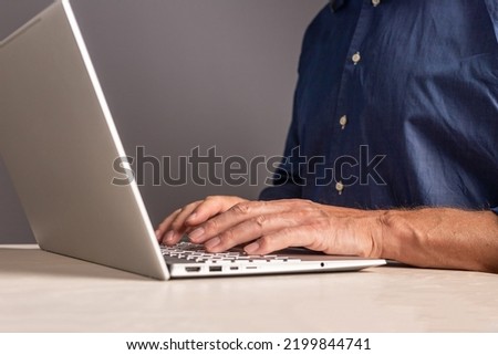 Man hands at laptop keyboard. Male typing email or document text for work or study, surfing Internet while sitting at table with computer. Human chatting with partners, colleagues. High quality photo