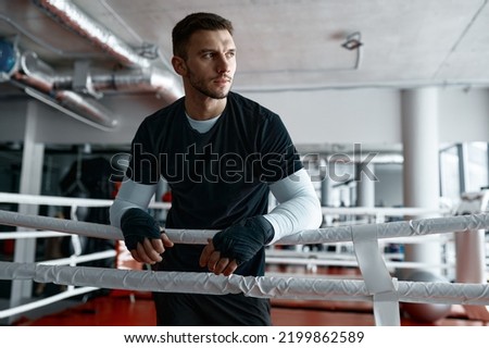 Male boxer leaned on ring ropes Royalty-Free Stock Photo #2199862589