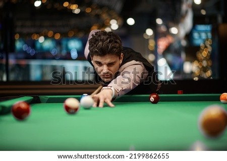 Portrait of man playing billiard Royalty-Free Stock Photo #2199862655