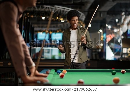 Young pool player rejoice successful hit Royalty-Free Stock Photo #2199862657