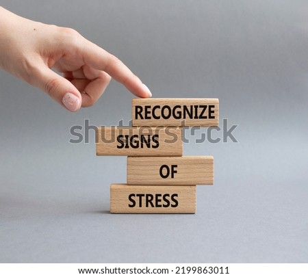 Recognize Signs of Stress symbol. Concept words Recognize Signs of Stress on wooden blocks. Beautiful grey background. Businessman hand. Medicine and Business concept. Copy space