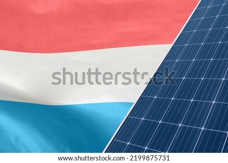 Solar panels against flag Luxembourg background. Solar battery generates a pure electricity. Concept of sustainable resources and renewable energy in Luxembourg