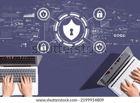 Cyber security theme with people working together with laptop computers
