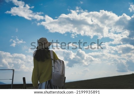 Back view of a woman looking at the blue sky Royalty-Free Stock Photo #2199935891