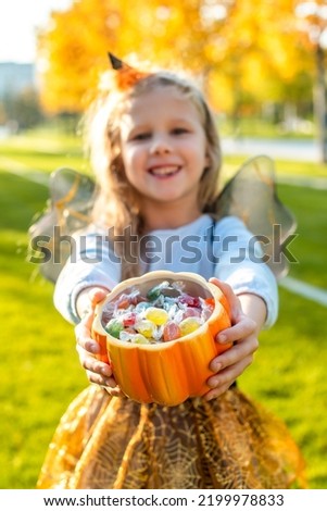 blonde girl dressed as a witch, wizard for halloween. Trick or treat. the child asks for candy