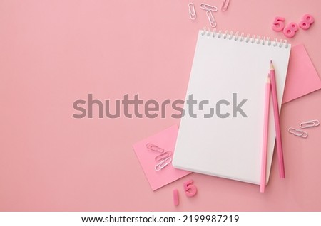 School supplies accessories stationery on pink background, flat lay, top view. Education supply accessory open empty notebook stuff. Back to school concept. Flatlay from above. Copy space.