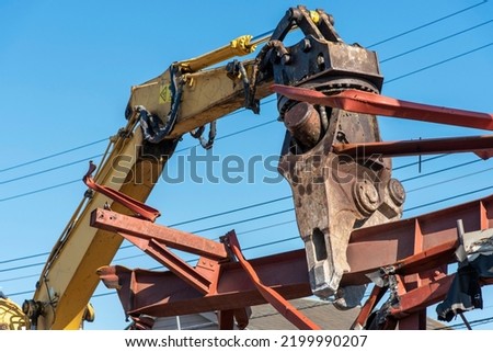 Demolition machine cutting steel frame, construction industry