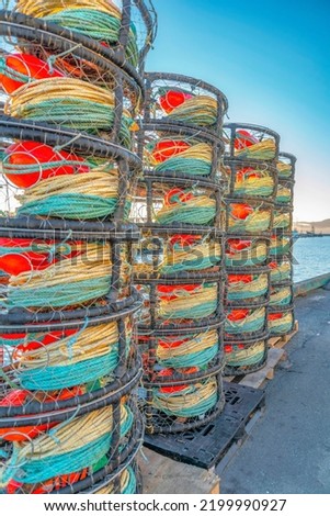 Fishing equipment and fish traps by the ocean with blue sky background. Close up view of netted baskets and strings used by fishermen to catch fish and seafood.