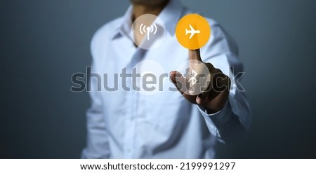 The man in the white shirt presses the air plane mode icon, indicating that he does not want to contact the outside world, disconnect or do not disturb. Royalty-Free Stock Photo #2199991297