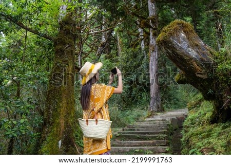Travel woman use cellphone to take photo on in forest