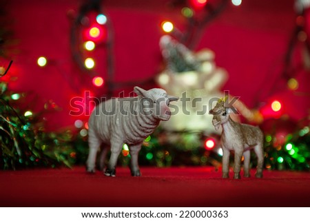 sheep and goat toy 2015 symbol of the year garland tinsel blur on a red background