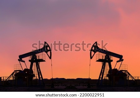Crude oil pump jack at oilfield on  sunset. Fossil crude output and fuels oil production. Oil drill rig and drilling derrick. Global crude oil Prices, energy, petroleum demand (OPEC+). Pump jack. 