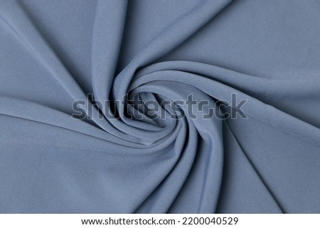 Swirled grey-colored fabric texture background. This fabric is made of cotton, wool, spandex, and special fibers. Royalty-Free Stock Photo #2200040529