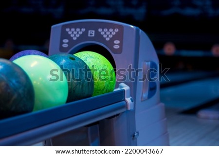 Colorful bowling balls on stand. Close up on ball return at bowling club