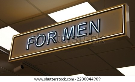 Close-up of a neon sign FOR MEN in a clothing store