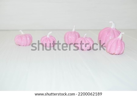 pale pink pumpkins on a light background , a place for text , an abstract Halloween concept