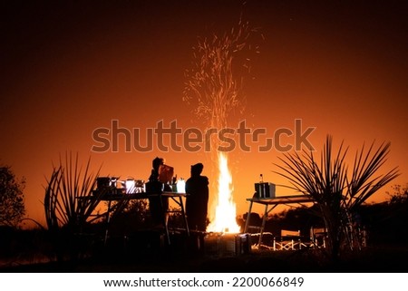 Bonfire and campfire cooking at sunset in the magical Okavango Delta in Botswana. Taken on a Trans Okavango wilderness boat safari in July 2022.