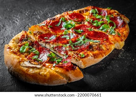 Pepperoni Pizza with Mozzarella cheese, salami, Tomato sauce, pepper, Spices. Italian pizza on Dark grey black slate background Royalty-Free Stock Photo #2200070661