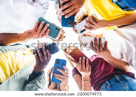 Teens in circle holding smart mobile phones - Multicultural young people using cellphones outside - Teenagers addicted to new technology concept