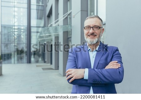 Portrait of senior gray haired handsome successful confident businessman man in glasses and suit