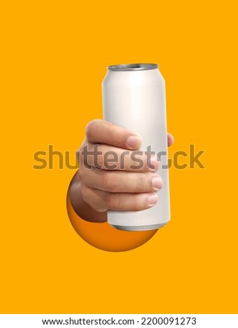 Man holding aluminum can on yellow background Royalty-Free Stock Photo #2200091273