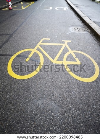 Yellow symbol of bicycle path on the road