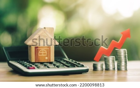 House is placed on the calculator and red arrow up on coin. concept calculating to buy a home. concept of increasing the cost of housing. High demand for real estate. growth of rent and mortgage rates Royalty-Free Stock Photo #2200098813