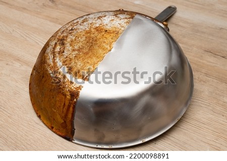 A frying pan that is half burnt and half polished Royalty-Free Stock Photo #2200098891