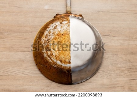 A frying pan that is half burnt and half polished