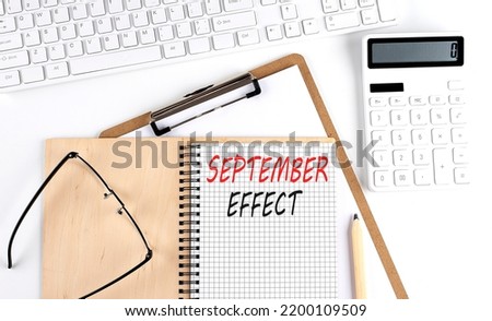 Notebook with the word SEPTEMBER EFFECT with keyboard and calculator on white background