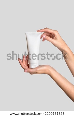 Woman hand showing cream product. Cosmetic product branding mockup. Daily skincare and body care routine. Female hand holding  cosmetic product mockup, close up.  Royalty-Free Stock Photo #2200131823