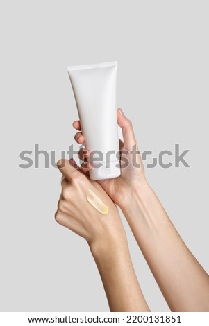 Woman hand showing cream product. Cosmetic product branding mockup. Daily skincare and body care routine. Female hand holding  cosmetic product mockup, close up.  Royalty-Free Stock Photo #2200131851
