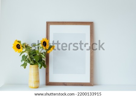 Decor details. Wooden frame, flowers and vase. Mockup idea. Stylish minimalist interior.