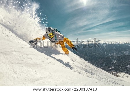 Real professional snowboarder rides at off-piste ski slope. Winter sports concept Royalty-Free Stock Photo #2200137413