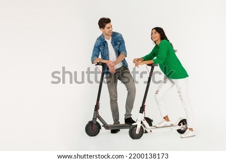 pretty stylish couple riding on electic kick scooter isolated on white studio background summer hipster style having fun together smiling happy