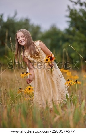 little girl in yellow dress princes collects in the grass high beautiful yellow flowers girl 6 years old long hair beautiful picture in the field of flowers