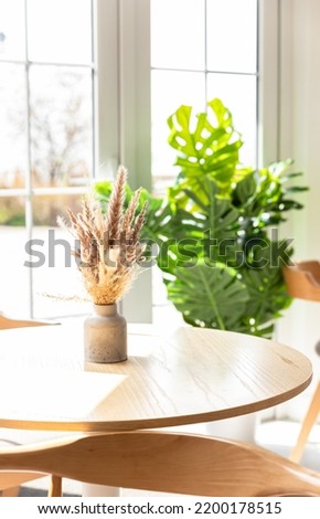 Vases with bouquet of dry flowers on wooden table. Minimalist in cafe interior design. Kinfolk or scandinavian style. Cozy design.