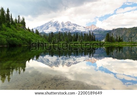Bench Lake with Mount Rainier reflection on a cloudy day. Bench Lake is along the Bench and Snow Lake trail in Mt Rainier National park, Washington.  Royalty-Free Stock Photo #2200189649