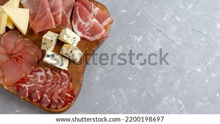 Appetizers table with differents antipasti, charcuterie, snacks and cheese on cutting board. Buffet party. Top view, copy space Royalty-Free Stock Photo #2200198697