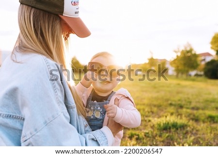 mom, the child is playing in the park, the child is wearing mom's sunglasses