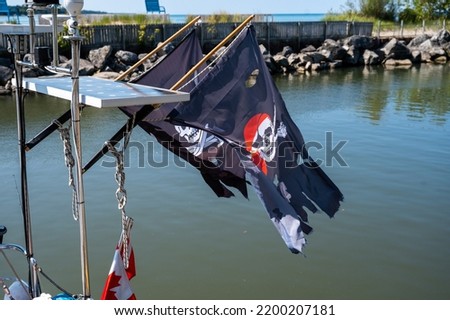 Old and wood sailboat with a pirate flag